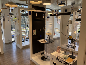 I piętro salonu KOMA Gdynia Redłowo – ekspozycja nowoczesnych lamp AQFORM. Minimalistyczne plafony, kinkiety i oświetlenie techniczne w aranżacji przypominającej studio projektowe.